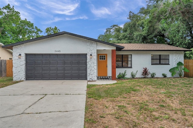 single story home with a garage and a front lawn