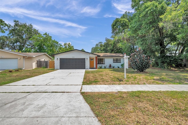 ranch-style home featuring a garage and a front lawn