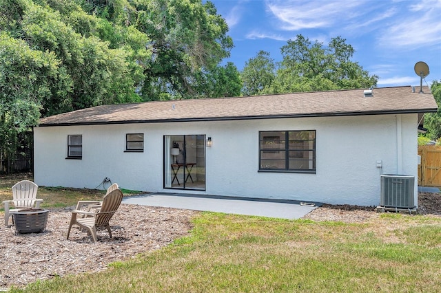 back of house with central AC unit, a patio area, and a lawn