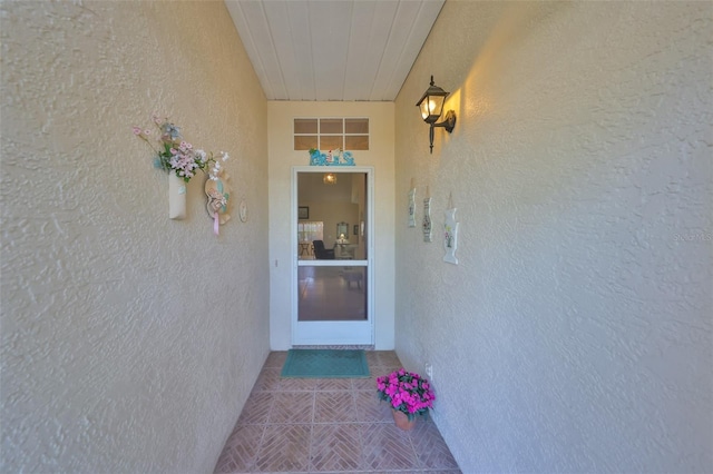 property entrance with visible vents and stucco siding