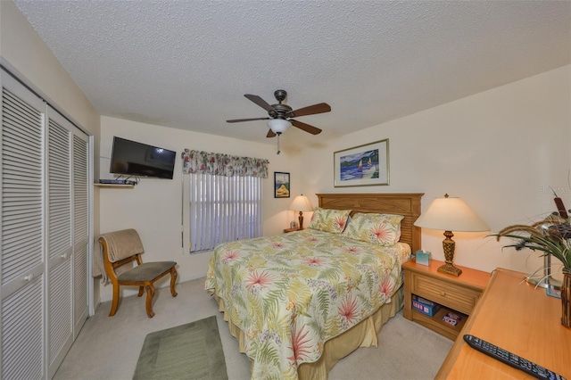 bedroom with ceiling fan, carpet, a closet, and a textured ceiling