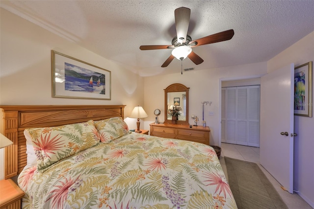 carpeted bedroom featuring ceiling fan, a textured ceiling, and a closet