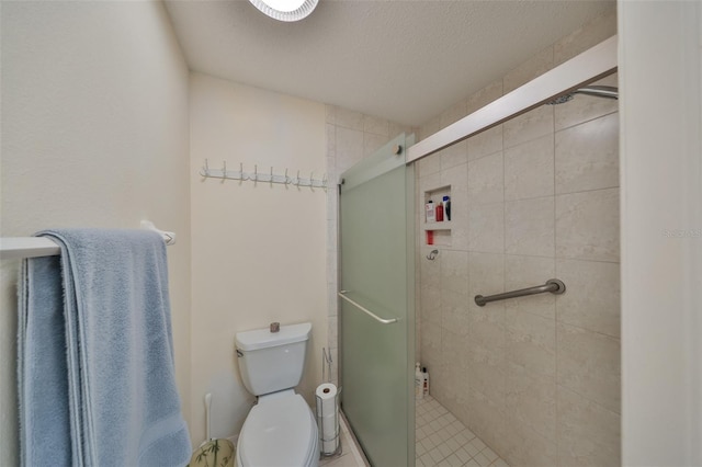 bathroom featuring a textured ceiling, a shower with door, and toilet