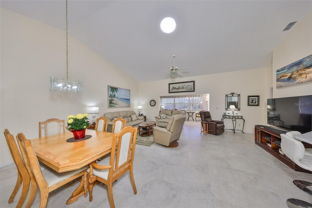 dining space featuring high vaulted ceiling, visible vents, and ceiling fan with notable chandelier