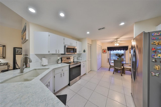 kitchen featuring tasteful backsplash, appliances with stainless steel finishes, sink, and white cabinets