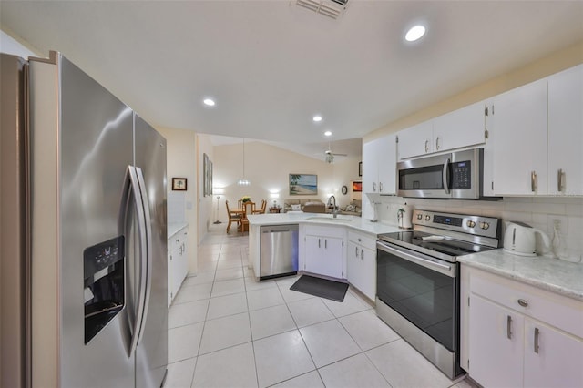 kitchen featuring visible vents, open floor plan, a sink, stainless steel appliances, and backsplash