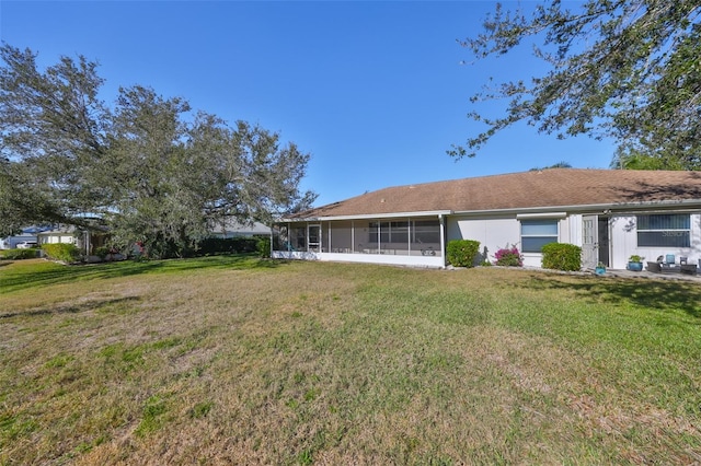 back of property featuring a sunroom and a yard