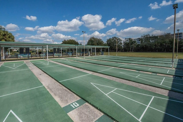 surrounding community featuring shuffleboard and a lawn