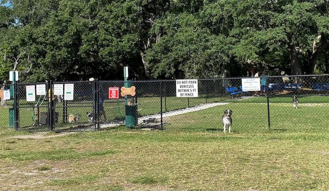 view of property's community with a lawn, fence, and a gate