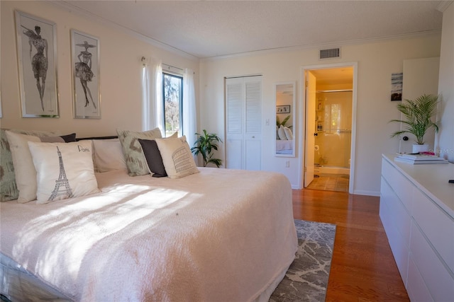 1433 Pine Glen Pl Unit G2, Tarpon Springs, FL 34688 - bedroom with visible vents, ornamental molding, ensuite bathroom, wood finished floors, and a closet