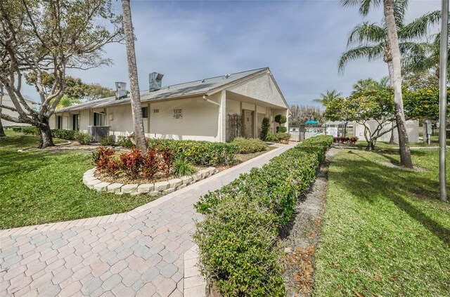 1433 Pine Glen Pl Unit G2, Tarpon Springs, FL 34688 - view of side of home featuring stucco siding and a lawn