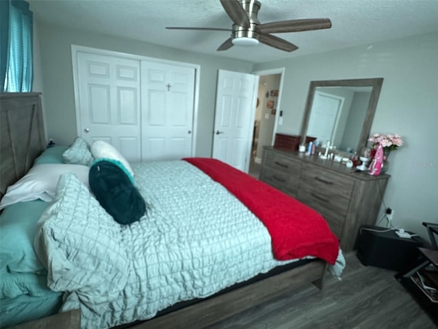 bedroom featuring ceiling fan, dark hardwood / wood-style floors, a textured ceiling, and a closet