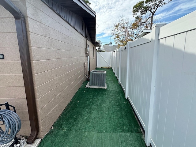 view of property exterior with central AC unit and a lawn