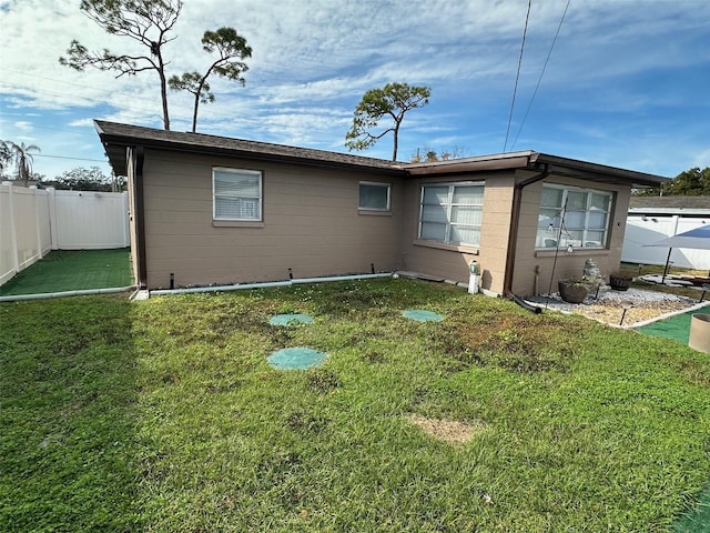 rear view of property with a yard