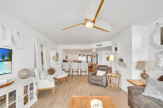 living room featuring light hardwood / wood-style floors and ceiling fan