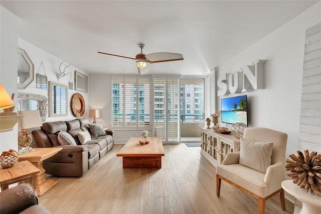 living room with ceiling fan and light wood-type flooring