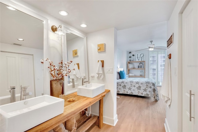 bathroom featuring wood-type flooring, vanity, and ceiling fan