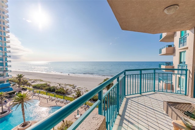 balcony featuring a water view and a beach view