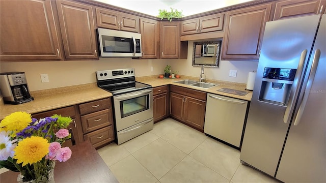 kitchen featuring stainless steel appliances, sink, and light tile patterned floors