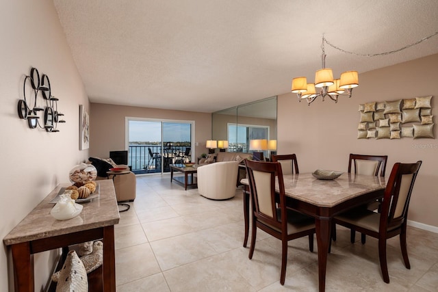 dining area with a chandelier, a textured ceiling, and light tile patterned floors