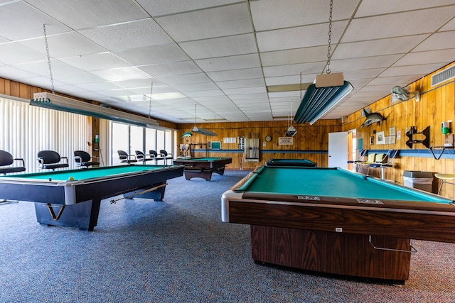 recreation room with dark colored carpet, a paneled ceiling, wooden walls, and billiards