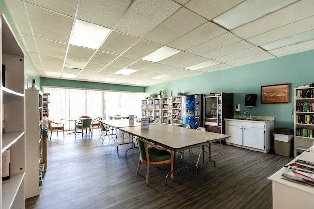 dining room with dark wood-type flooring and a paneled ceiling