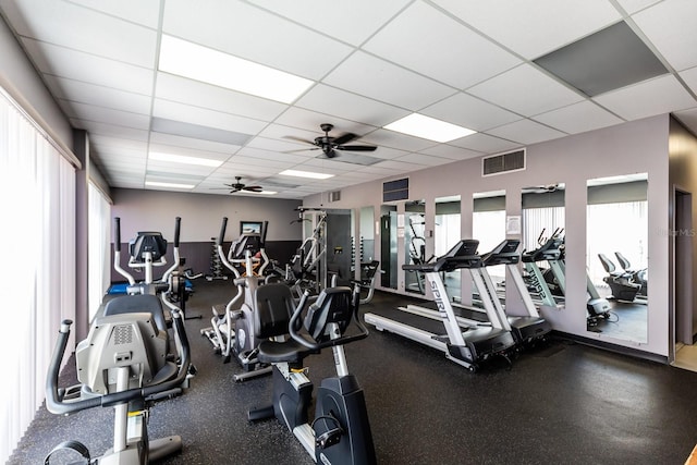 workout area with a paneled ceiling and ceiling fan