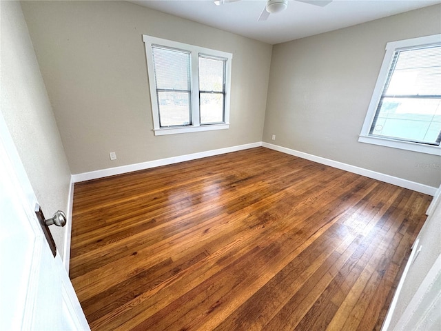 empty room featuring ceiling fan, a healthy amount of sunlight, and hardwood / wood-style floors