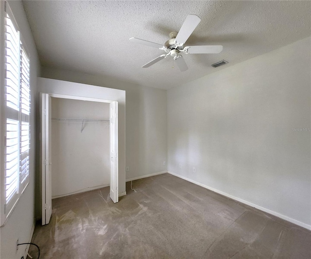 unfurnished bedroom featuring ceiling fan, a closet, carpet floors, and a textured ceiling