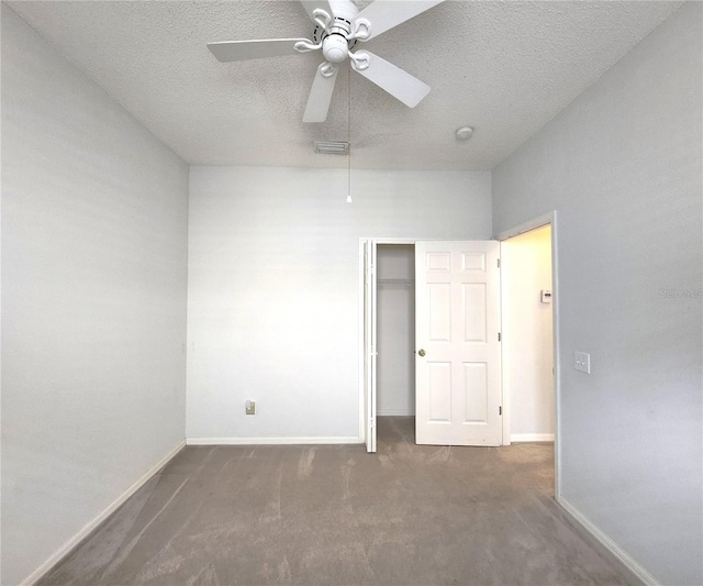 carpeted spare room with ceiling fan and a textured ceiling