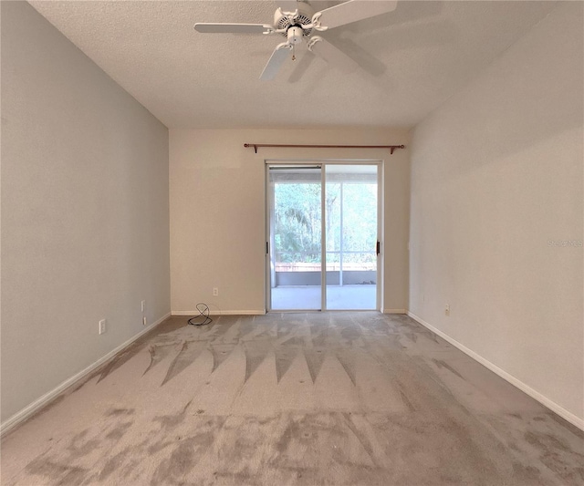 empty room with ceiling fan, light carpet, and a textured ceiling