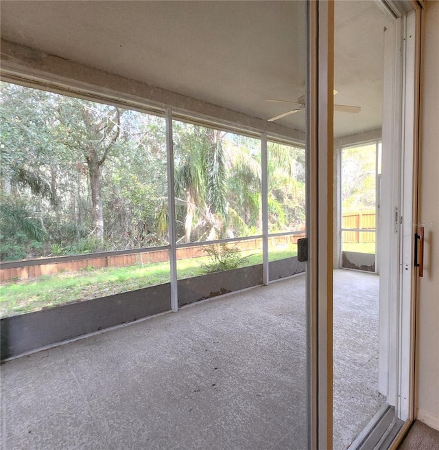 unfurnished sunroom with ceiling fan