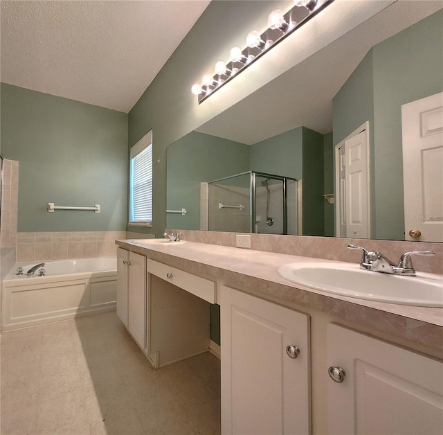 bathroom with vanity, separate shower and tub, and a textured ceiling