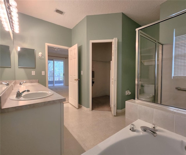 bathroom with independent shower and bath, vanity, and a textured ceiling