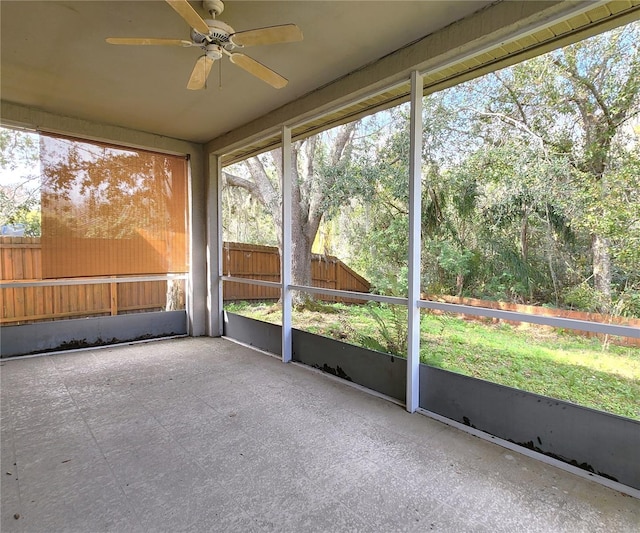 unfurnished sunroom with ceiling fan