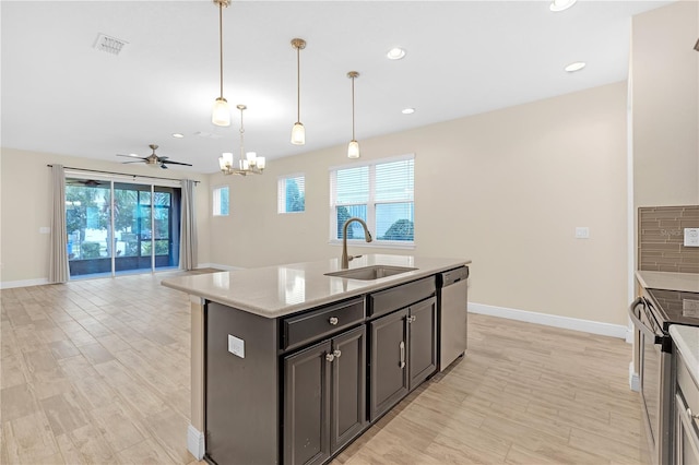 kitchen with electric range oven, dishwasher, sink, hanging light fixtures, and a kitchen island with sink