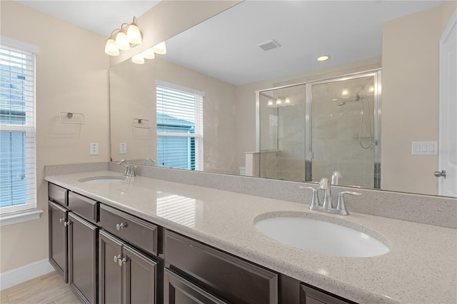 bathroom with vanity and a shower with door