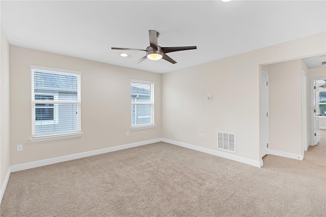 carpeted spare room featuring ceiling fan