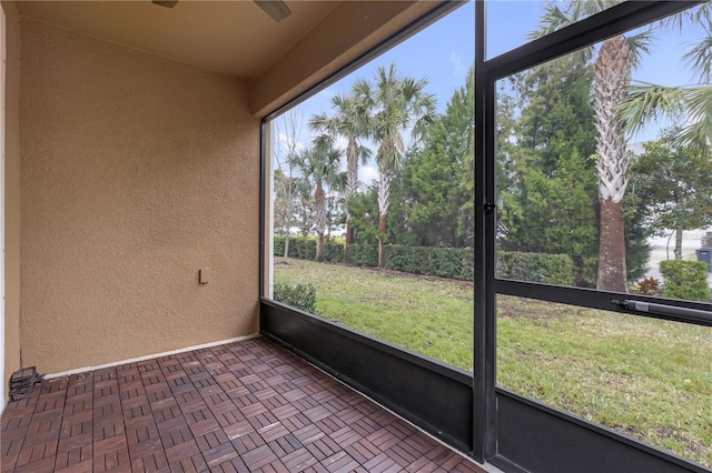 unfurnished sunroom with ceiling fan