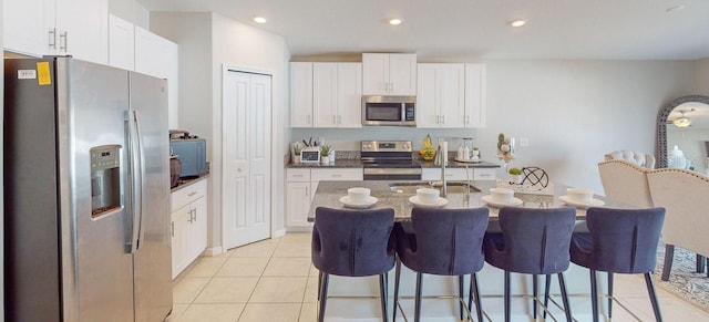 kitchen with white cabinetry, light tile patterned floors, and stainless steel appliances