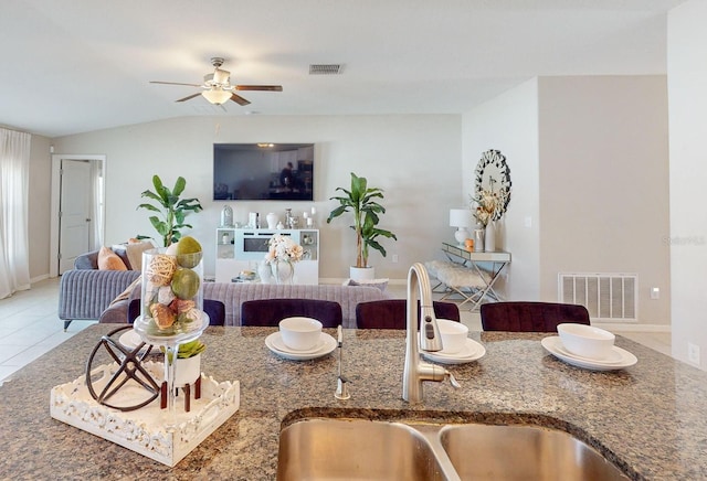 tiled living room featuring vaulted ceiling, ceiling fan, and sink