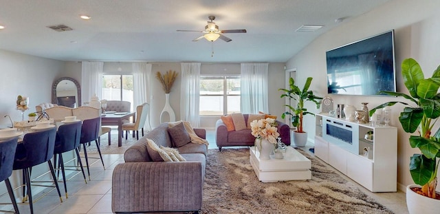 living room with ceiling fan and light tile patterned flooring