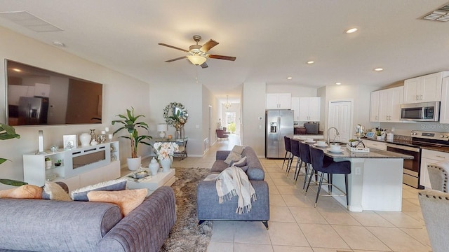 living room featuring light tile patterned flooring, sink, and ceiling fan