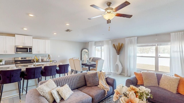 living room featuring light tile patterned floors and ceiling fan