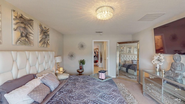 carpeted bedroom featuring a textured ceiling and a notable chandelier