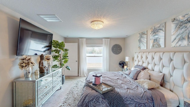 bedroom featuring light colored carpet and a textured ceiling