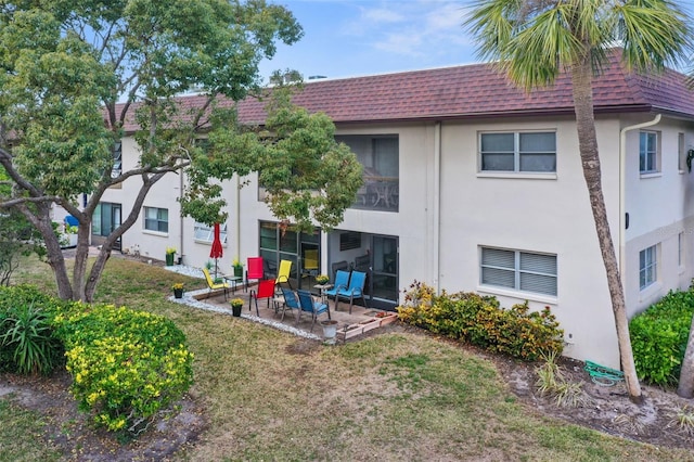 rear view of house featuring a yard and a patio area