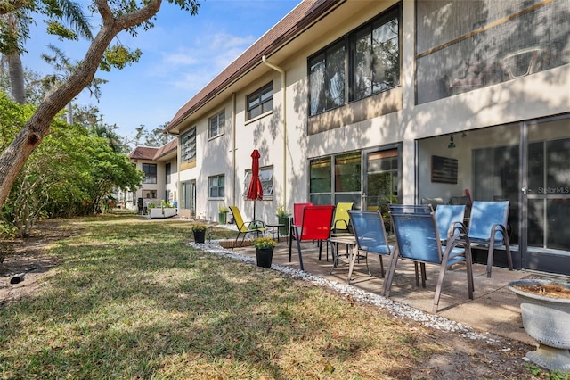 rear view of house with a lawn and a patio