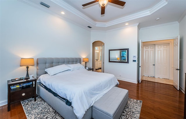 bedroom featuring crown molding, ceiling fan, dark hardwood / wood-style floors, and a raised ceiling