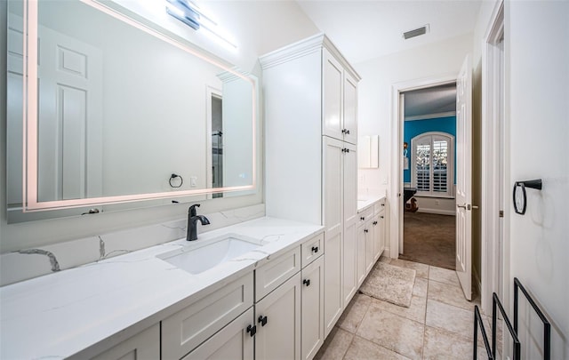 bathroom with ornamental molding and vanity